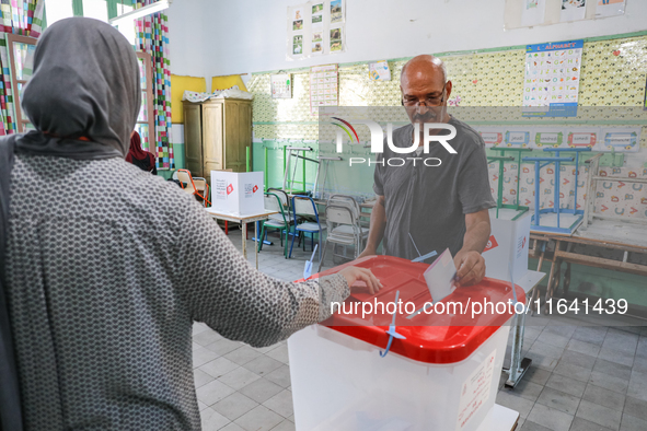 A Tunisian man casts his ballot at a polling station during the presidential election in Ariana, a suburb of Tunis, Tunisia, on October 6, 2...