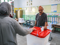 A Tunisian man casts his ballot at a polling station during the presidential election in Ariana, a suburb of Tunis, Tunisia, on October 6, 2...