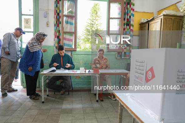 Tunisians prepare to cast their votes at a polling station during the presidential election in Ariana, a suburb of Tunis, Tunisia, on Octobe...