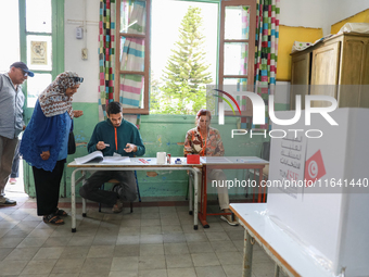 Tunisians prepare to cast their votes at a polling station during the presidential election in Ariana, a suburb of Tunis, Tunisia, on Octobe...