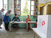 Tunisians prepare to cast their votes at a polling station during the presidential election in Ariana, a suburb of Tunis, Tunisia, on Octobe...