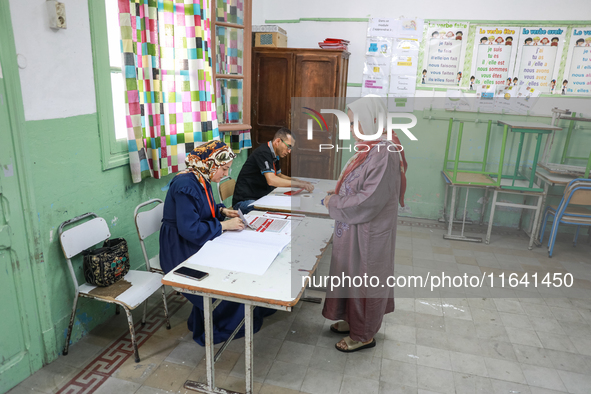 A Tunisian elderly woman prepares to cast her vote at a polling station during the presidential election in Ariana, a suburb of Tunis, Tunis...