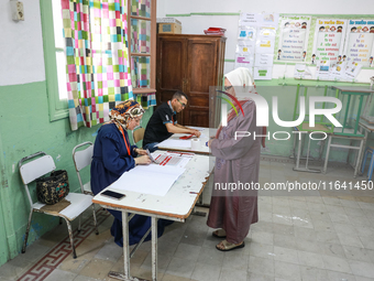 A Tunisian elderly woman prepares to cast her vote at a polling station during the presidential election in Ariana, a suburb of Tunis, Tunis...