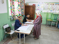 A Tunisian elderly woman prepares to cast her vote at a polling station during the presidential election in Ariana, a suburb of Tunis, Tunis...