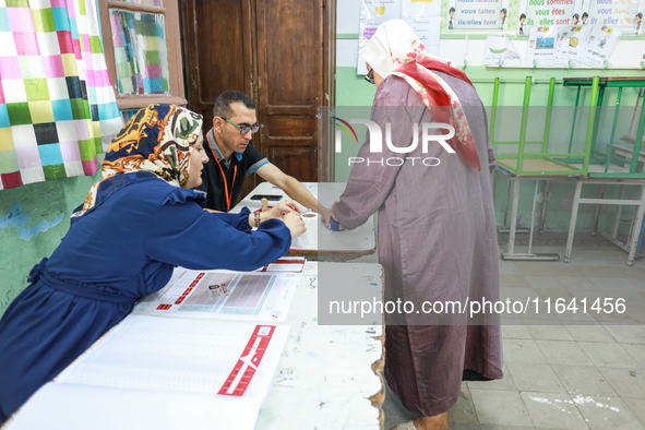 A Tunisian woman casts her ballot at a polling station during the presidential election in Ariana, a suburb of Tunis, Tunisia, on October 6,...