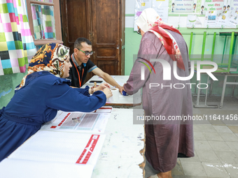 A Tunisian woman casts her ballot at a polling station during the presidential election in Ariana, a suburb of Tunis, Tunisia, on October 6,...