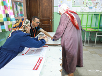 A Tunisian woman casts her ballot at a polling station during the presidential election in Ariana, a suburb of Tunis, Tunisia, on October 6,...