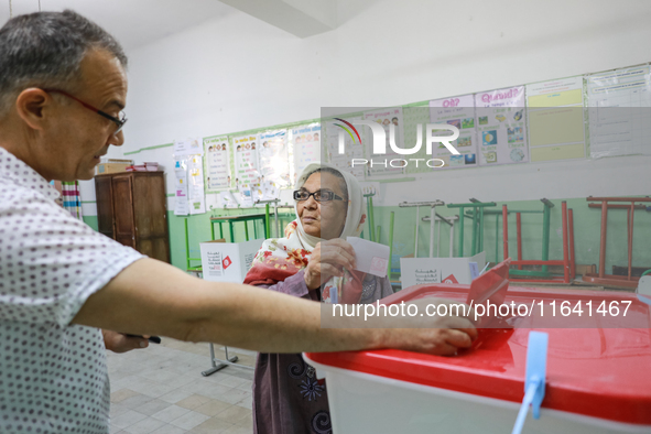 A Tunisian elderly woman casts her ballot at a polling station during the presidential election in Ariana, a suburb of Tunis, Tunisia, on Oc...