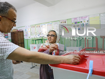 A Tunisian elderly woman casts her ballot at a polling station during the presidential election in Ariana, a suburb of Tunis, Tunisia, on Oc...