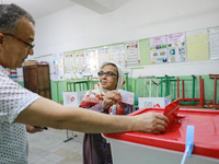 A Tunisian elderly woman casts her ballot at a polling station during the presidential election in Ariana, a suburb of Tunis, Tunisia, on Oc...