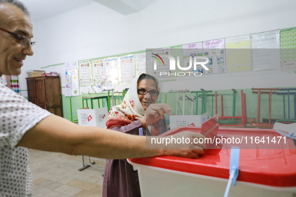 A Tunisian elderly woman casts her ballot at a polling station during the presidential election in Ariana, a suburb of Tunis, Tunisia, on Oc...