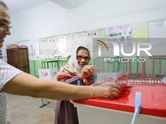 A Tunisian elderly woman casts her ballot at a polling station during the presidential election in Ariana, a suburb of Tunis, Tunisia, on Oc...