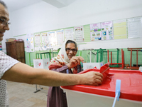 A Tunisian elderly woman casts her ballot at a polling station during the presidential election in Ariana, a suburb of Tunis, Tunisia, on Oc...