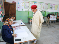 A Tunisian elderly man prepares to cast his vote at a polling station during the presidential election in Ariana, a suburb of Tunis, Tunisia...