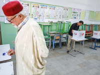 A Tunisian man fills his ballot paper at a polling station during the presidential election in Ariana, a suburb of Tunis, Tunisia, on Octobe...