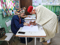 A Tunisian elderly man prepares to cast his vote at a polling station during the presidential election in Ariana, a suburb of Tunis, Tunisia...