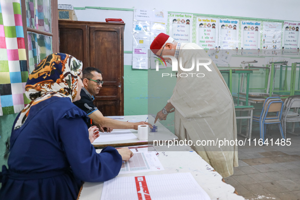 A Tunisian elderly man has his finger inked as he prepares to cast his vote at a polling station during the presidential election in Ariana,...