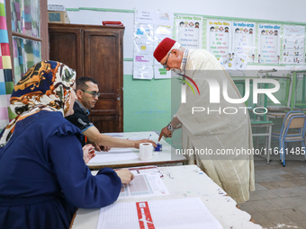 A Tunisian elderly man has his finger inked as he prepares to cast his vote at a polling station during the presidential election in Ariana,...