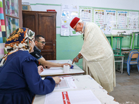 A Tunisian elderly man has his finger inked as he prepares to cast his vote at a polling station during the presidential election in Ariana,...