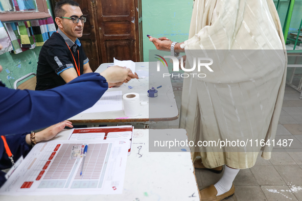 A Tunisian elderly man has his finger inked as he prepares to cast his vote at a polling station during the presidential election in Ariana,...