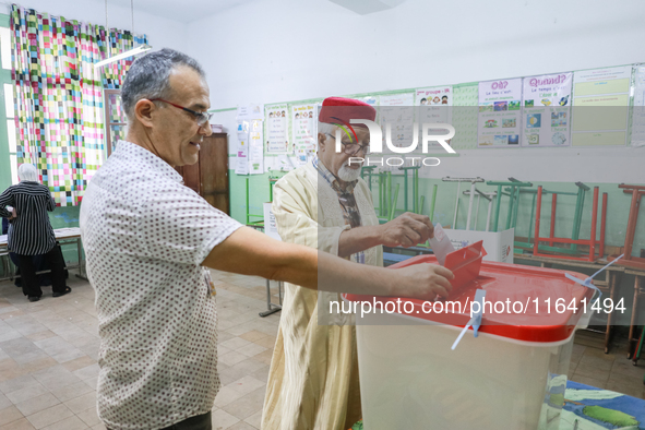 A Tunisian elderly man casts his ballot at a polling station during the presidential election in Ariana, a suburb of Tunis, Tunisia, on Octo...