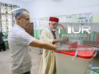 A Tunisian elderly man casts his ballot at a polling station during the presidential election in Ariana, a suburb of Tunis, Tunisia, on Octo...