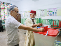 A Tunisian elderly man casts his ballot at a polling station during the presidential election in Ariana, a suburb of Tunis, Tunisia, on Octo...