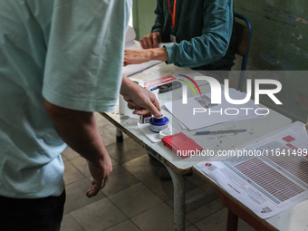 A Tunisian man inks his finger as he prepares to cast his vote at a polling station during the presidential election in Ariana, a suburb of...