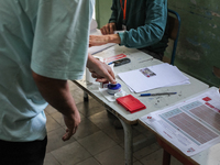 A Tunisian man inks his finger as he prepares to cast his vote at a polling station during the presidential election in Ariana, a suburb of...