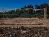 Kashmiri boys play cricket inside a net installed on a roadside in Sopore, Jammu and Kashmir, India, on October 6, 2024 (