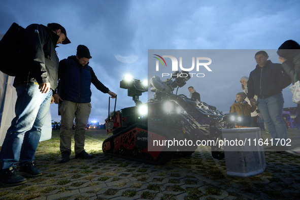 Visitors look at a Shark Robotics firefighting robot at the Warsaw Institute of Aviation in Warsaw, Poland on 04 October, 2024. The annual A...