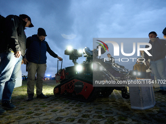 Visitors look at a Shark Robotics firefighting robot at the Warsaw Institute of Aviation in Warsaw, Poland on 04 October, 2024. The annual A...