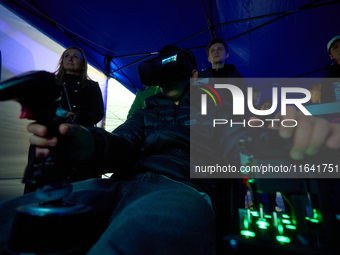 A visitor flies a fighter jet simulator at the Warsaw Institute of Aviation in Warsaw, Poland on 04 October, 2024. The annual Aviation Night...