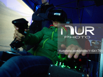 A visitor flies a fighter jet simulator at the Warsaw Institute of Aviation in Warsaw, Poland on 04 October, 2024. The annual Aviation Night...