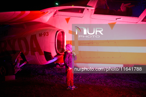 A child pulls his hat over his face while posing for a photo at the Warsaw Institute of Aviation in Warsaw, Poland on 04 October, 2024. The...