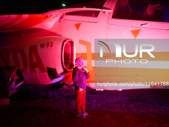 A child pulls his hat over his face while posing for a photo at the Warsaw Institute of Aviation in Warsaw, Poland on 04 October, 2024. The...