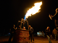 People have their photo taken while flames emit from the bruner of a hot air balloon system at the Warsaw Institute of Aviation in Warsaw, P...