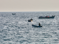 Fishing boats are in the ocean along Paruthiyoor Beach in Paruthiyoor, Kerala, India, on April 15, 2024. (