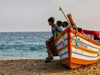 People sit in a fishing boat along Paruthiyoor Beach in Paruthiyoor, Kerala, India, on April 15, 2024. (