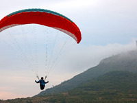 A paraglider flies in the air at a cloud-deep flight camp in Zaozhuang, China, on October 6, 2024. (