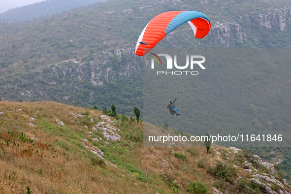 A paraglider flies in the air at a cloud-deep flight camp in Zaozhuang, China, on October 6, 2024. 