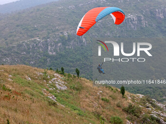 A paraglider flies in the air at a cloud-deep flight camp in Zaozhuang, China, on October 6, 2024. (