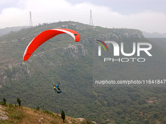 A paraglider flies in the air at a cloud-deep flight camp in Zaozhuang, China, on October 6, 2024. (