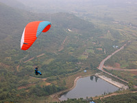 A paraglider flies in the air at a cloud-deep flight camp in Zaozhuang, China, on October 6, 2024. (