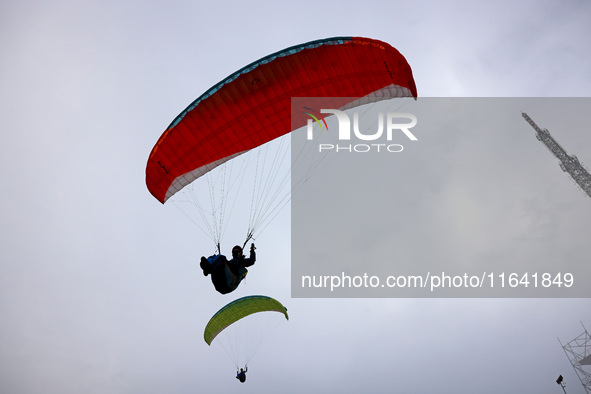 A paraglider flies in the air at a cloud-deep flight camp in Zaozhuang, China, on October 6, 2024. 