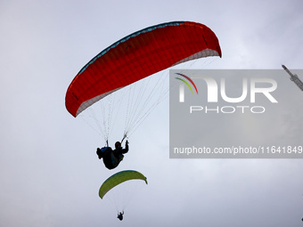 A paraglider flies in the air at a cloud-deep flight camp in Zaozhuang, China, on October 6, 2024. (