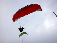 A paraglider flies in the air at a cloud-deep flight camp in Zaozhuang, China, on October 6, 2024. (