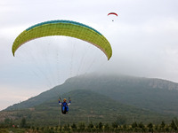 A paraglider flies in the air at a cloud-deep flight camp in Zaozhuang, China, on October 6, 2024. (