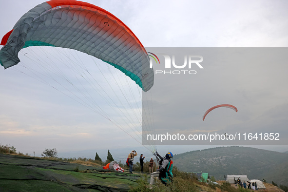 A paraglider flies in the air at a cloud-deep flight camp in Zaozhuang, China, on October 6, 2024. 