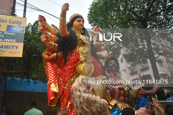 Workers load a Durga idol onto a truck for transport to a pandal, or a temporary platform, ahead of the Durga Puja festival in Kolkata, Indi...